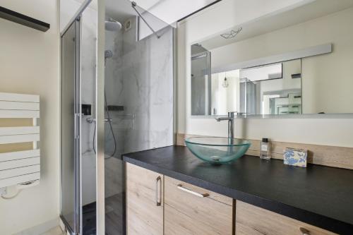 La salle de bains est pourvue d'un lavabo en verre sur un comptoir. dans l'établissement Trocadéro/Victor Hugo - Confort absolu, à Paris