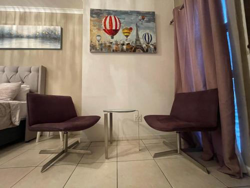 twee stoelen en een tafel in een kamer bij DOMIN LUXURY SUITES in Kaapstad
