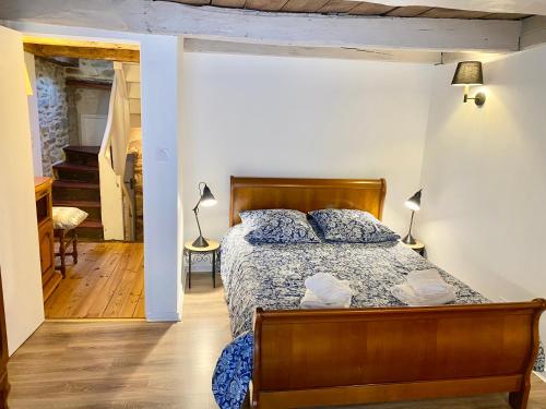 une chambre avec un lit avec une tête de lit en bois dans l'établissement Les Volets Blancs, à Dinan
