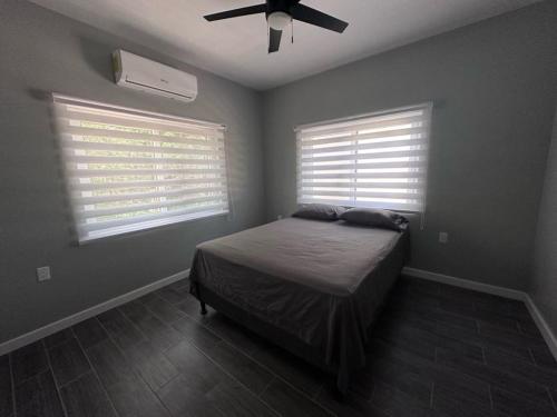 - une chambre avec un lit et un ventilateur de plafond dans l'établissement Baquis Island Bungalow, à Utila