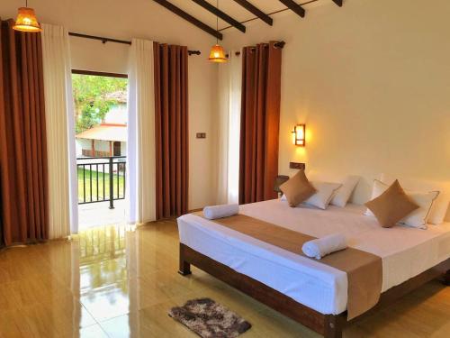 a bedroom with a bed and a large window at Linton Villa in Kalutara