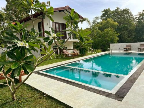 a swimming pool in front of a villa at Linton Villa in Kalutara