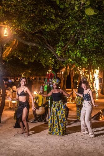 a group of women dancing on the street at night at Paradise Beach Hotel & Resort in West Bay