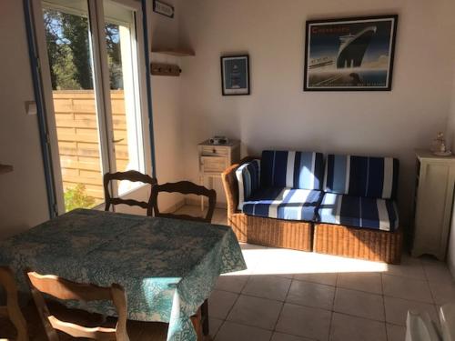 un salon avec une table et un canapé dans l'établissement La petite maison, à Denneville