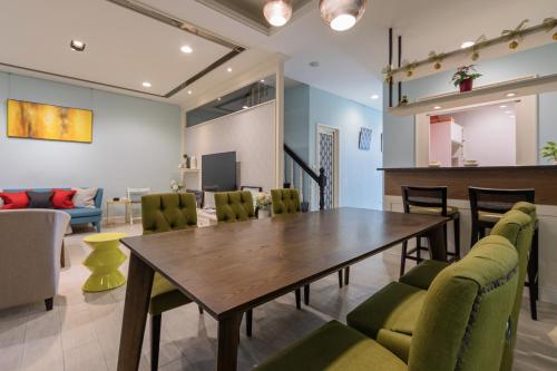 a dining room with a wooden table and green chairs at Sommer 19 B&B in Luodong