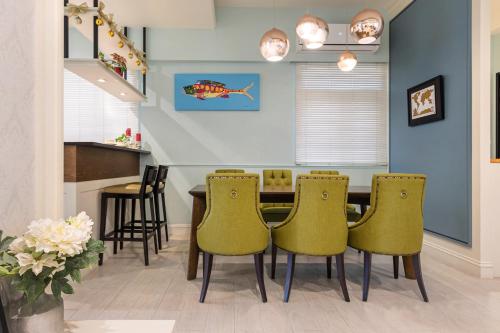 a dining room with a table and yellow chairs at Sommer 19 B&B in Luodong