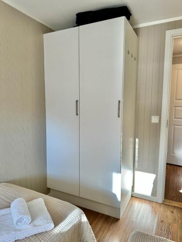 a bedroom with a large white cabinet with two towels at Leknes Airport Apartment in Leknes