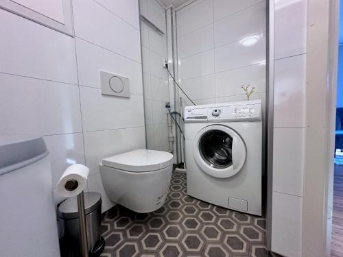 a bathroom with a washing machine and a toilet at Leknes Airport Apartment in Leknes