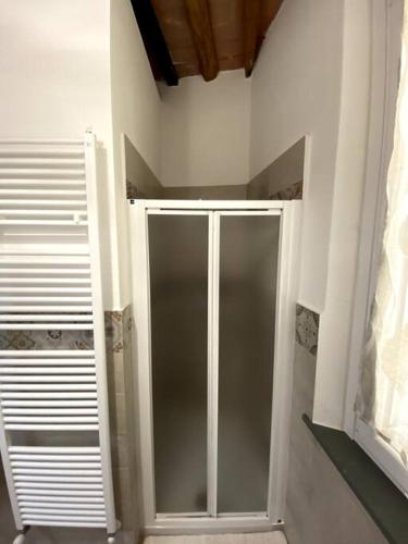 a bathroom with a glass shower door in a room at Casa Loretta - bright and spacious in Vicopisano in Vicopisano