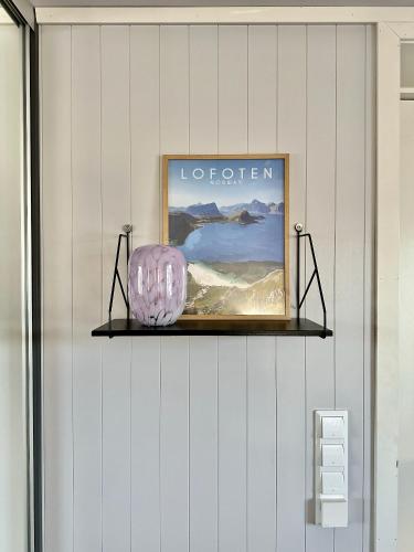 a picture on a wall with a shelf at Leknes Airport Apartment in Leknes