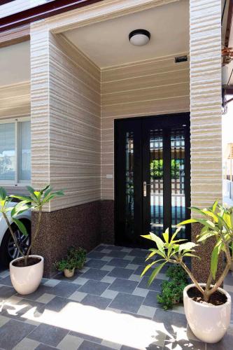 a front door of a house with potted plants at Sommer 19 B&B in Luodong