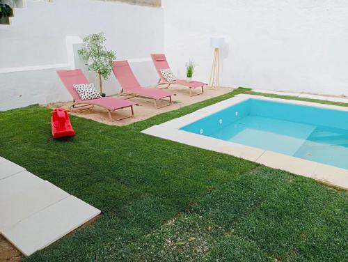 a yard with chairs and a swimming pool at Maison M&M private pool 13 guests in Almeirim