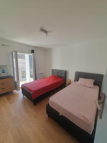 une chambre avec deux lits et une fenêtre dans l'établissement Nyons : appartement refait à NEUF, à Nyons