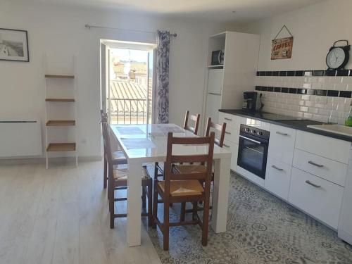une cuisine avec une table et des chaises dans une cuisine dans l'établissement Nyons : appartement refait à NEUF, à Nyons