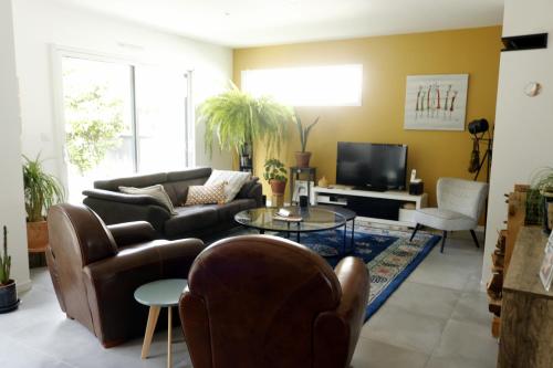 un salon avec un canapé et une télévision dans l'établissement maison calme, à Baden