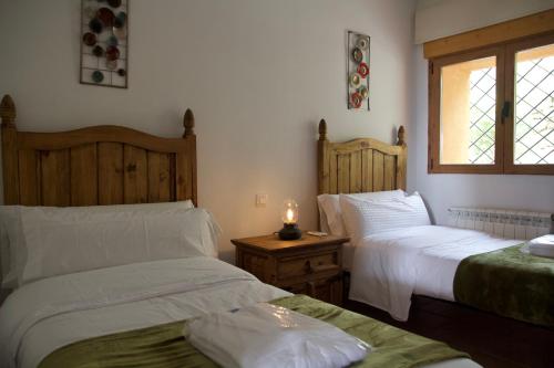1 dormitorio con 2 camas y una vela sobre una mesa en 'El Mirador de Sotillo', un Oasis de Confort con Piscina y Jacuzzis, en Sotillo de la Adrada
