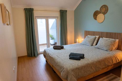 a bedroom with a bed with two towels on it at Apartments Baleal: Balconies and Pool in Ferrel