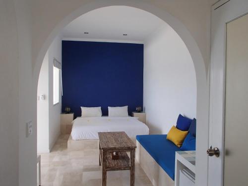 a bedroom with a white bed and a blue wall at Aquaterrace Amed in Amed