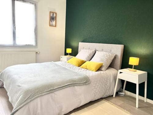 1 dormitorio con cama blanca y pared verde en Le Nirvana ~ Jolie t2 avec Balcon / 2 min du parc en Jaunay-Marigny