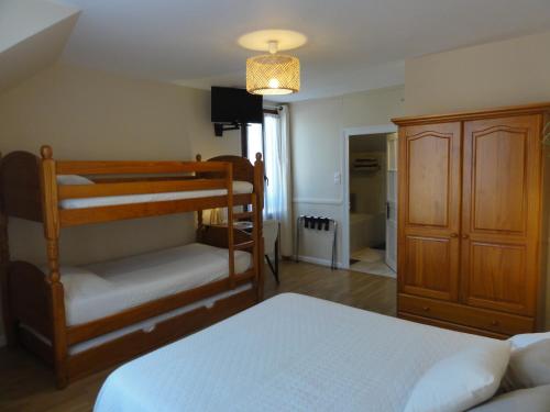 PayzacにあるHotel des Voyageursのベッドルーム1室(二段ベッド2台、クローゼット付)