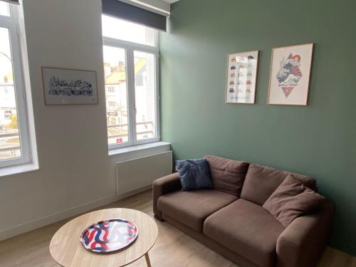 un salon avec un canapé et une table dans l'établissement Appartement calme et lumineux, à Boulogne-sur-Mer