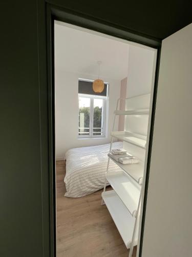 une chambre avec un lit et un miroir dans une pièce dans l'établissement Appartement calme et lumineux, à Boulogne-sur-Mer