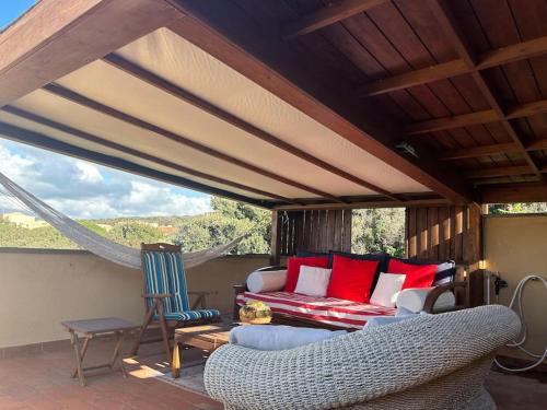 - un salon avec un canapé et des chaises sur une terrasse dans l'établissement Maya's house, à Punta Ala