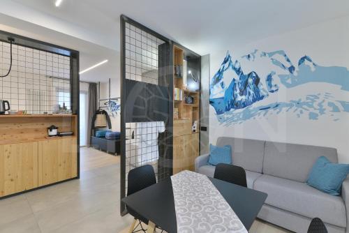 Le Lion Apartments - Bike & Ski في أَويستا: غرفة معيشة مع أريكة وطاولة