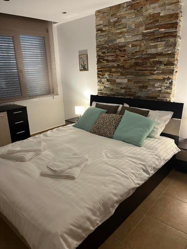 una camera da letto con un grande letto bianco e un muro in pietra di Peaceful Escape a Kavala