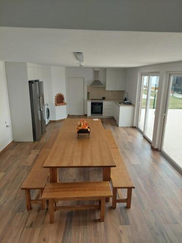 ein Wohnzimmer mit einem Holztisch und einer Küche in der Unterkunft Quinta das Laranjeiras in Marinhais