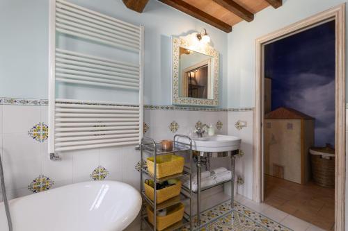 een badkamer met een bad, een wastafel en een spiegel bij Borgo Mommialla Casa Alessandra in Gambassi Terme