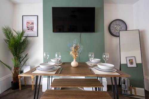 a dining room table with plates and wine glasses at Central 2 bedroom flat in the heart of the lanes in Brighton & Hove