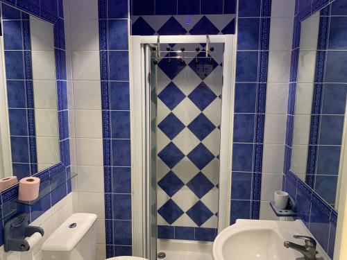 a blue tiled bathroom with a shower and a sink at Chez Chebil in rue Halevy - near the sea in Nice