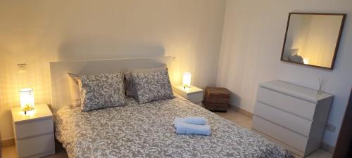 um quarto com uma cama com 2 candeeiros e um espelho em Magua Home: Apartment at 25 meters from Canteras beach em Las Palmas de Gran Canaria