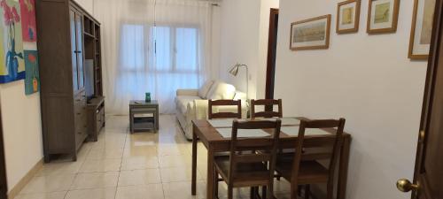 uma sala de estar com uma mesa e um sofá em Magua Home: Apartment at 25 meters from Canteras beach em Las Palmas de Gran Canaria