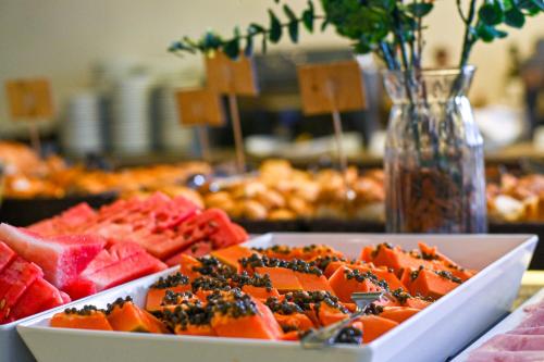 a table with a plate of watermelon and other food at Casa Nova Hotel in Rio de Janeiro