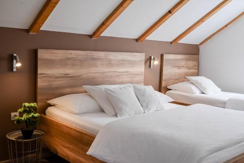 - 2 lits dans une chambre avec des oreillers blancs dans l'établissement Guesthouse Rubcic, à Rakovica