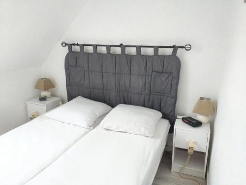 een slaapkamer met een bed met 2 witte kussens bij Maison de 2 chambres a Le Crotoy a 300 m de la plage avec jardin amenage et wifi in Le Crotoy