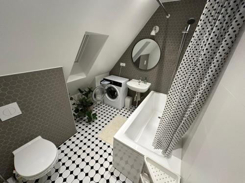 a bathroom with a toilet and a sink and a tub at Cozy private house with backyard and hot tub in Pärnu