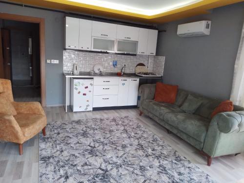 a living room with a couch and a kitchen at Güven Rezidans in Buca