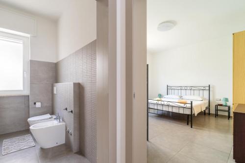ein Bad mit einem WC und ein Schlafzimmer mit einem Bett in der Unterkunft In Collina in Matino