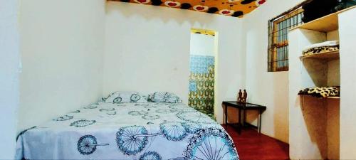 a bedroom with a bed with a blue and white blanket at Petit Hollande guest rooms in Abémé