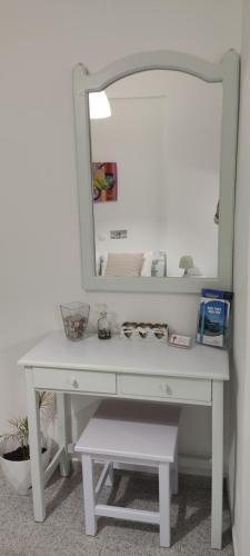 a white dressing table with a mirror on it at Garden Rooms in Matala