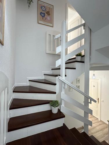 a staircase in a home with white and wood floors at "LAS CAMELIAS SOMO" un lugar para desconectar!! Vistas al MAR!! in Somo