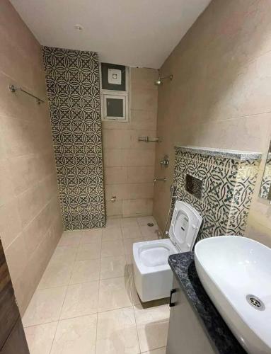 uma casa de banho com um WC branco e um lavatório. em Your home stay em Rishikesh