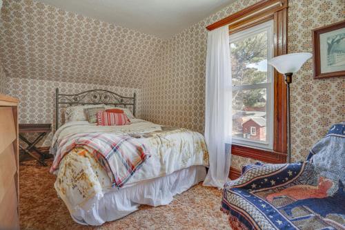 a bedroom with a bed and a window and a chair at Quiet Farmhouse Retreat with Fire Pit - Pets Welcome! in Milltown