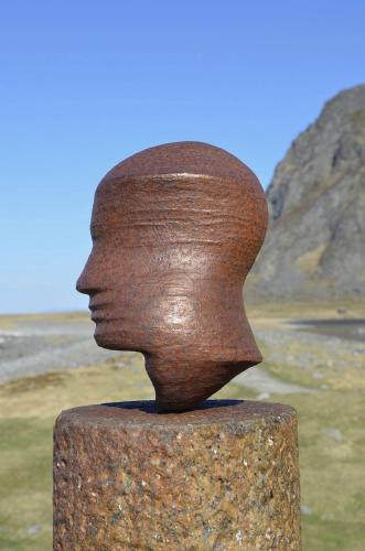 a statue of a head on top of a rock at Leknes Airport Apartment in Leknes