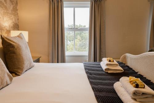 a hotel room with towels on a bed with a window at Spacious Chester City Centre Stylish Townhouse. W/ Parking in Chester