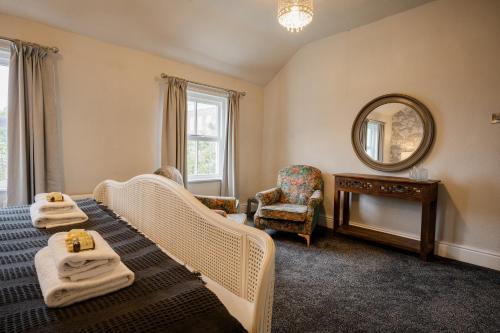 a bedroom with two beds and a mirror and a chair at Spacious Chester City Centre Stylish Townhouse. W/ Parking in Chester