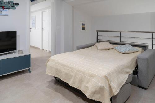 1 dormitorio con 1 cama y TV de pantalla plana en Le case di vada - Il Faro, en Vada
